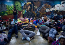 Nella foto la carovana di migranti in marcia verso gli Usa si riposano sdraiati per terra.