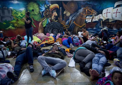Nella foto la carovana di migranti in marcia verso gli Usa si riposano sdraiati per terra.