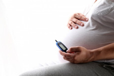 Il pancione di una donna incinta che si controlla il livello di diabete.