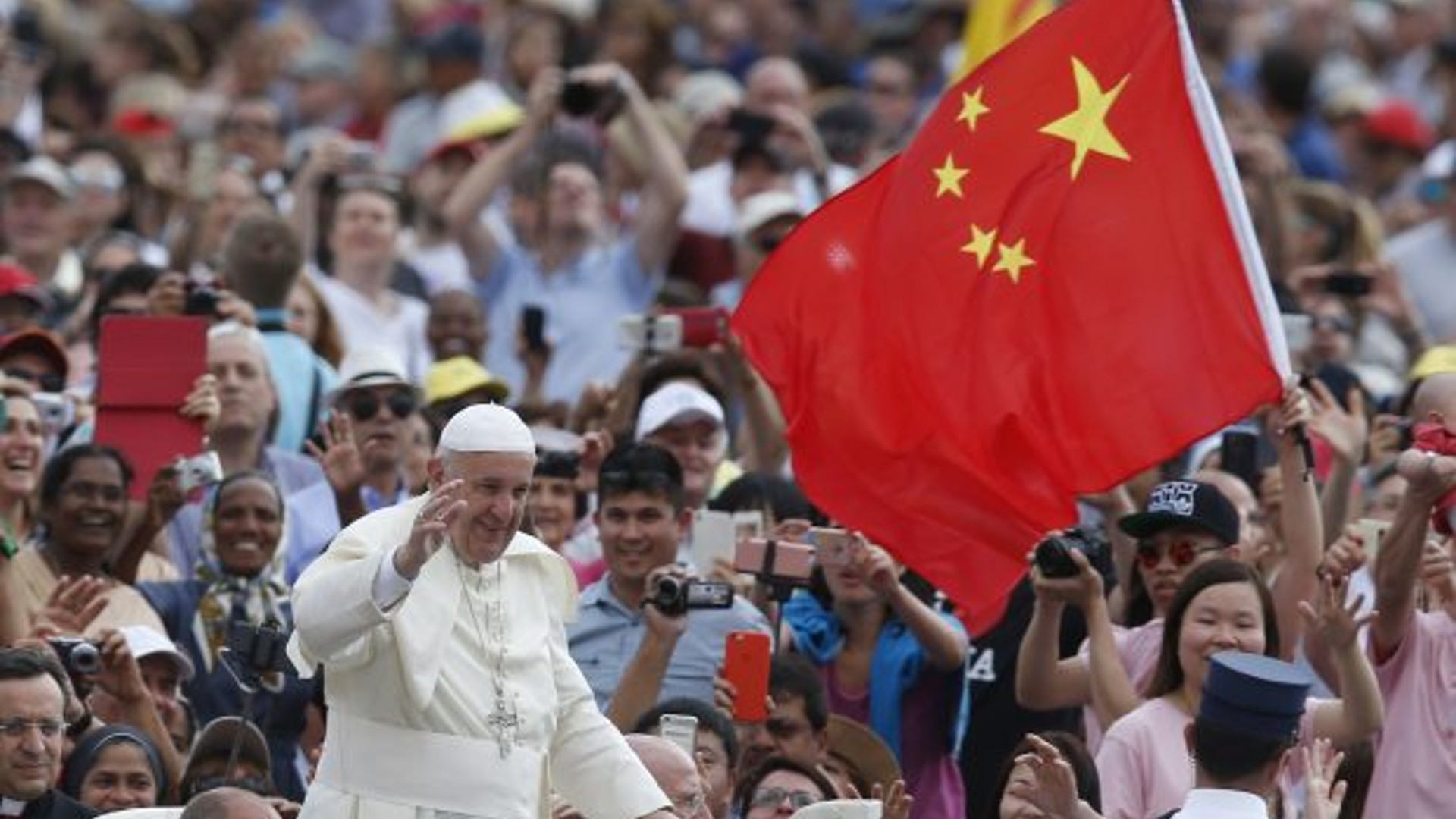 Bandiere della Cina salutano il passaggio di Papa Francesco.