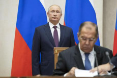 Vladimir Putin alle spalle del ministro degli esteri russo Sergei Lavrov mentre firma dei documenti. Missili