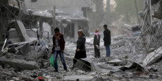 Sirie, due persone tra le macerie dopo un bombardamento.
