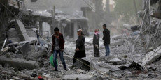 Sirie, due persone tra le macerie dopo un bombardamento.
