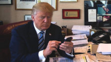 Il presidente Donald Trump twittando con il suo cellulare.