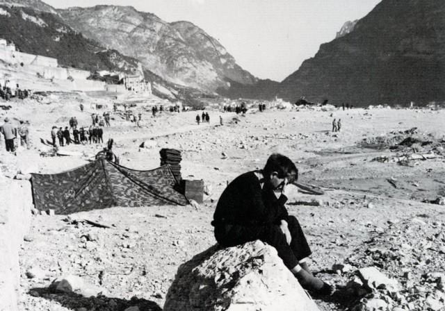 55 anni dalla tragedia del Vajont: nella foto d'epoca un ragazzo seduto su un macigno piange..