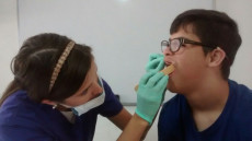 Higiene bucal, odontoitra revisando la boca de un muchacho con sindrome de Down