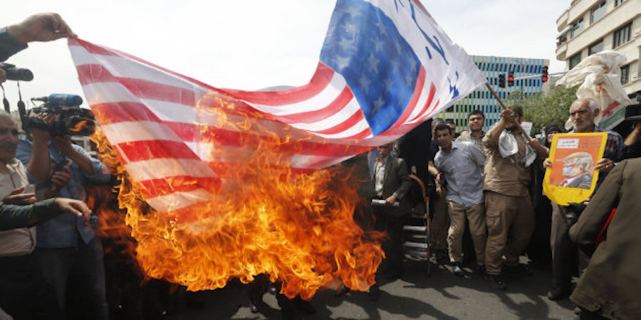 Bandiera americana bruciata per strada in Iran.