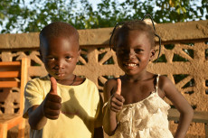 Due bambini africani con il pollice in alto. Italiani
