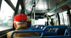 Un anziano, ripreso di spalle, seduto su un autobus. Sconti