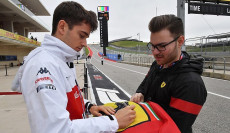 Charles Leclerc firma un autografo ad un tifoso della Ferrari.