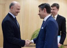 Stretta di mano tra il commissario Ue per gli affari economici Pierre Moscovici (S) e il presidente del Consiglio Giuseppe Conte sotto gli occhi del vicepresidente della Commissione Ue Valdis Dombrovskis (D). Tria