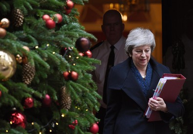 Theresa May passa al lato di un albero di Natale.