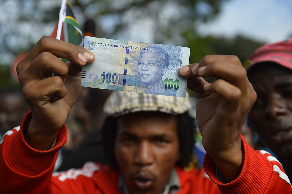 Un sudafricano mostra una banconota con l'immagine di Mandela.
