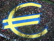 Il simbolo dell'Euro sovrapposto ad una folla.