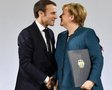 La Cancelliera tedesca Angela Merkel e il Presidente francese Emmanuel Macron dopo la firma dell'accordo si stringono la mano.