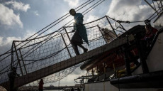 Sbarco di migranti su una passerella di una barca