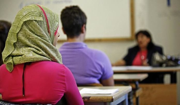 Una ragazza con il velo islamico a scuola durante le lezioni.