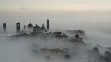 Meteo: paese in collina immerso nella nebbia mattutina.