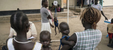 Africa: donne in strada con bambini piccoli in braccio.