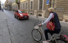 Una signora in bicicletta in città. Codice della strada