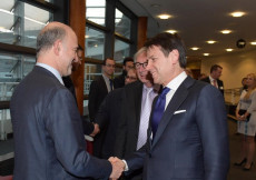 Stretta di mano tra il commissario Ue per gli affari economici Pierre Moscovici (S) e il presidente del Consiglio Giuseppe Conte.