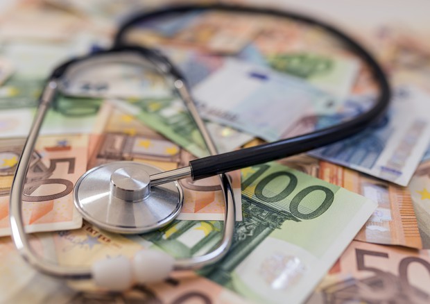 Sanità, stetoscopio ed euro su un tavolo.