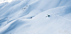 Sciatore solitario in fuori pista sulla neve.