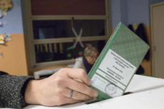 Una mano deposita una scheda elettorale nell'urna in Sardegna