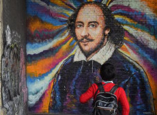 Un ragazzo di spalle guarda un murale con l'effige di William Shakespeare (1564-1616) creata dall'artista James Cochran.