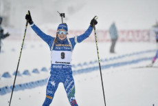Dorothea Wierer a braccia alzate taglia il traguardo della 12,5 km mass start nel Campionato del mondo di Biathlon.