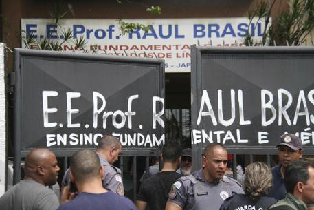 Ufficiali della polizia bloccano l'entrata alla Raul Brasil State School in Suzano, Brasile.