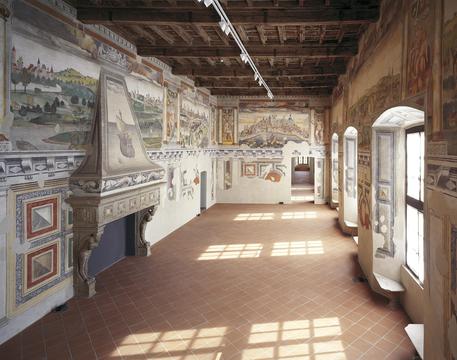Il corridoio di un salone di museo con quadri appesi alle pareti. Fai