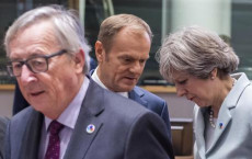 Theresa May parla con Donald Tusk e Jean-Claude Juncker in primo piano.