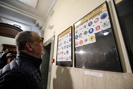Roberto Calderoli (Lega) osserva i simboli esposti nella bacheca durante la consegna dei contrassegni elettorali presso il Viminale per le elezioni europee.