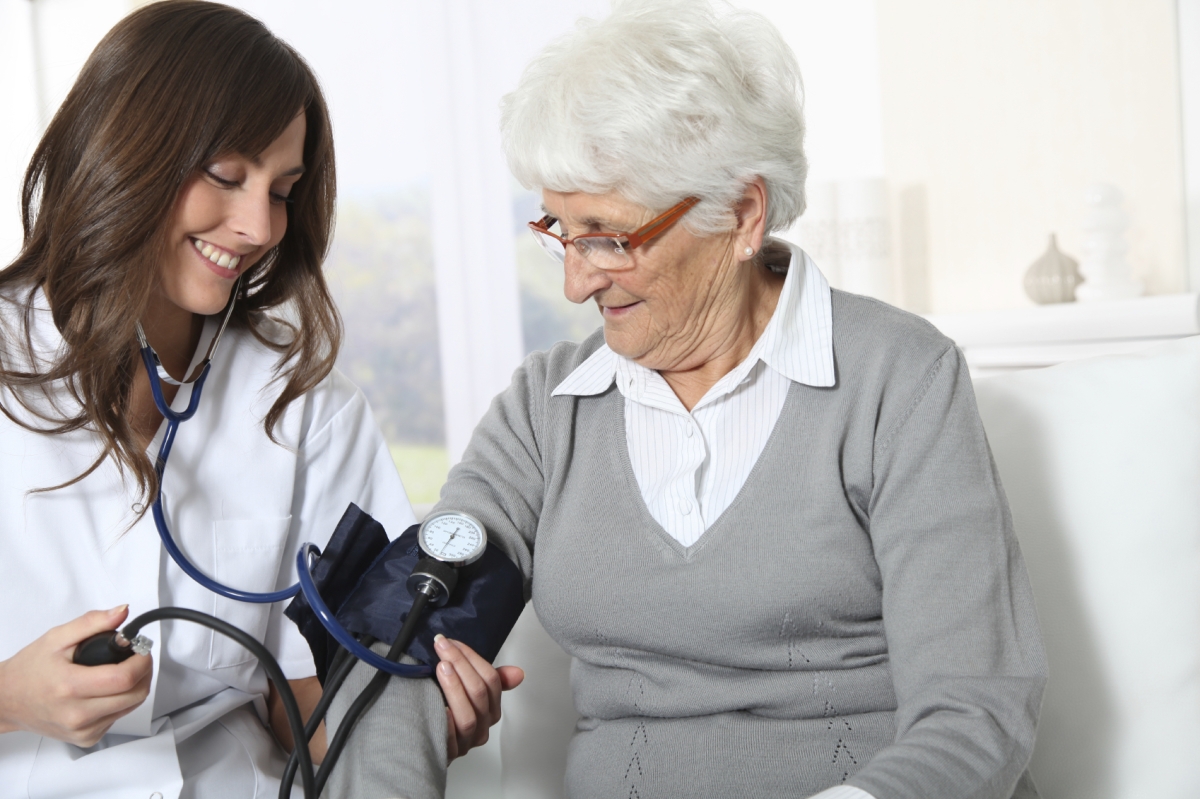 Antihipertensivos: Enfermera midiendo la tensión a una señora de la tercera edad.