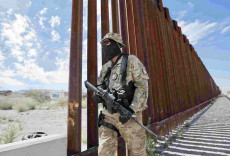 Un soldato americano pattuglia il muro al confine Messico Usa
