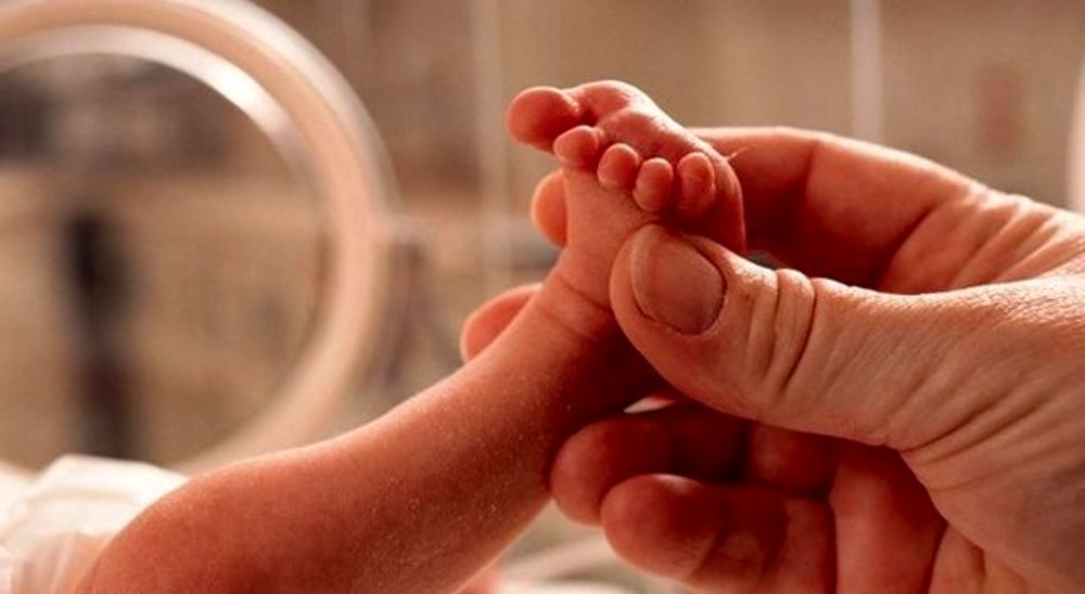 Cina: La mano della mamma accarezza il piedino del neonato