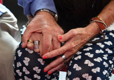 Over65: Le mani di una coppia di anziani si stringono.