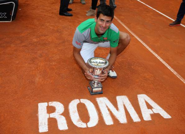 Il tennista vincitore della Coppa sul campo da tennis in terra battuta e la scritta Roma.