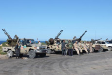 Veicoli blindati e militari schierati al bordo della strada in Libia.