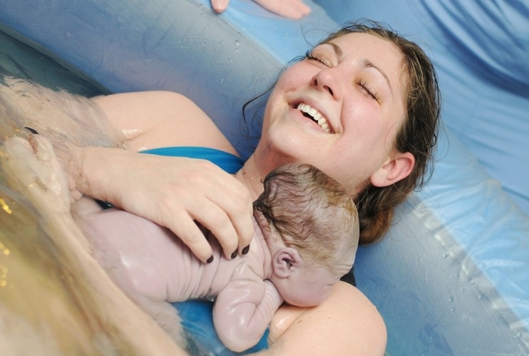 Una mujer con su bebé recién nacido.