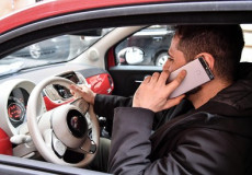 Un ragazzo con il cellulare all'orecchio mentre guida.