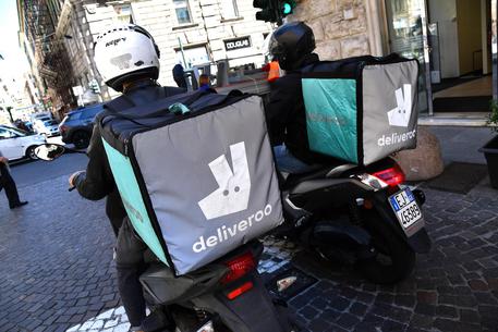 Due rider della Deliveroo impegnati in una consegna nel centro della città di Genova.