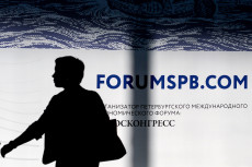 L'ombra di una persona camminando davanti al logo del Forum di San Pietroburgo.
