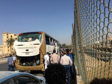 Ufficiali della polizia egiziana parlano con un gruppo di turisti dell'autobus investito dalla bomba.