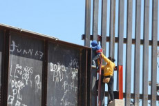 Una donna aiuta il figlio a saltare il muro che divide il Messico degli Stati Uniti in località Puente Negro, Ciudad Juarez.Archivio.