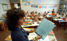 Nell'immagine d'archivio (settembre 2005), una maestra elementare in aula apre il registro di classe davanti ai suoi alunni.