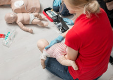 Un'insegnate da corso di primi aiuti in caso di soffocamento, simulazione con bambole.
