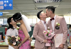 Due coppie dello stesso sesso si baciano dopo la cerimonia del matrimonio in Taiwan.