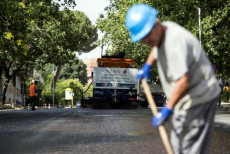 Operai a lavoro durante la sperimentazione dell'asfalto sigillante in via Galba, Roma.